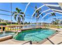 Enclosed pool with a hot tub and view of the lake at 4403 Via Del Villetti Dr, Venice, FL 34293
