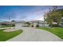 Inviting home showcases a well-maintained lawn, spacious driveway, and a welcoming entrance, ideal for a Gathering at 447 Rotonda Cir, Rotonda West, FL 33947