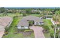 An aerial view of a landscaped home with a tile roof, golf course in the background, and a water view at 4532 Chase Oaks Dr, Sarasota, FL 34241