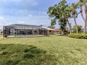 Spacious backyard with a screened-in pool enclosure, mature trees and a well-maintained lawn at 455 Rubens E Dr, Nokomis, FL 34275