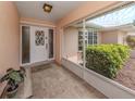 Welcoming screened front porch featuring a decorative door and tiled floor at 455 Rubens E Dr, Nokomis, FL 34275