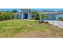 A home with a well-kept lawn, fresh landscaping, and a walkway leading to a bold blue front door at 4624 Caribou Ave, North Port, FL 34287
