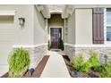 Covered entryway with stone accents, leading to a dark wood front door and stylish exterior lighting at 5222 Granite Dust Pl, Palmetto, FL 34221