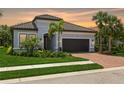 Beautiful single Gathering home with a tile roof, paver driveway, manicured lawn and tropical landscaping at 5581 Piccolo St, Nokomis, FL 34275
