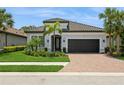 Beautiful single Gathering home with a tile roof, paver driveway, manicured lawn and tropical landscaping at 5581 Piccolo St, Nokomis, FL 34275