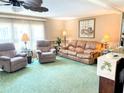 Inviting living room featuring plush seating, a ceiling fan, and natural light from the large window at 603 Leisure, Venice, FL 34285