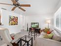 Cozy living room with neutral color scheme, comfortable seating, and ample natural light from the large windows at 607 Bay Point Ave, Nokomis, FL 34275