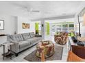 Bright living room featuring white tile floors, modern furniture, and views of the outdoor pool at 607 Bay Point Ave, Nokomis, FL 34275