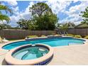 Inviting backyard pool and spa, surrounded by lush landscaping and a privacy fence for relaxing outdoor living at 607 Bay Point Ave, Nokomis, FL 34275