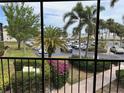A screened balcony overlooking a parking area with many palm trees and landscaping at 618 Bird Bay S Dr # 212, Venice, FL 34285