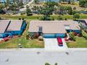 An aerial view of a charming home with a red car parked in the driveway, surrounded by lush landscaping at 657 Foxwood Blvd, Englewood, FL 34223