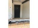 A black front door, brick planter, and white chair at 744 Avenida Estancia # 142, Venice, FL 34292
