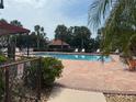 Community pool with palm trees and lounge chairs under a sunny sky at 744 Avenida Estancia # 142, Venice, FL 34292