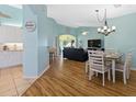 Open-concept living room with wood floors, dining area, and view to the lanai at 904 Addington Ct # 204, Venice, FL 34293