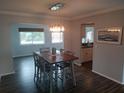 Elegant dining room featuring stylish light fixture, hardwood floors, and a wood dining table at 1001 Sandlewood Dr, Venice, FL 34293