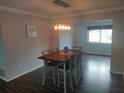 Elegant dining room featuring stylish light fixture, hardwood floors, and a wood dining table at 1001 Sandlewood Dr, Venice, FL 34293