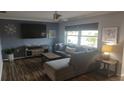 Comfortable living room with a large sectional sofa, stylish decor, and hardwood floors at 1001 Sandlewood Dr, Venice, FL 34293