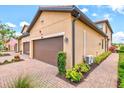 Exterior view of a townhome with two car garage, landscaping, and paver sidewalk at 10808 Tarflower Dr # 102, Venice, FL 34293