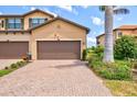 Townhome with a two-car garage and brick paver driveway in a well-maintained community at 10808 Tarflower Dr # 102, Venice, FL 34293