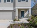 Inviting home exterior showcasing blue door, stone accents, manicured landscaping, and attached two car garage at 11228 Fieldstone Dr, Palmetto, FL 34221
