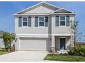 Charming two-story home featuring blue shutters, manicured lawn, and an attached two car garage at 11228 Fieldstone Dr, Palmetto, FL 34221