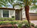 Inviting entryway with a decorative glass door, a paver walkway, and lush greenery at 12728 Richezza Dr, Venice, FL 34293
