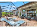 Relaxing screened-in patio area with comfortable seating, a ceiling fan, and an outdoor television at 13873 Karina St, Venice, FL 34293