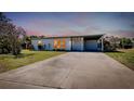 A well lit home with a driveway and carport at dusk at 140 Poinsettia Ne Cir, Port Charlotte, FL 33952