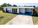 Charming home with a well-maintained lawn and a covered carport and driveway at 140 Poinsettia Ne Cir, Port Charlotte, FL 33952
