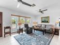 Cozy living room with plush seating, ceiling fans, and large windows for natural light at 18302 Burkholder Cir, Port Charlotte, FL 33948