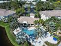 Aerial view of community pool with palm trees and waterfall feature near clubhouse at 212 Triano Cir # 212, Venice, FL 34292