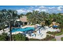 Community pool area featuring palm trees, lounge chairs, and waterfall feature for upscale living at 212 Triano Cir # 212, Venice, FL 34292