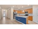 A modern kitchen featuring stainless steel appliances, white countertops, and an island with a blue accent at 2150 Snapdragon Ln, Venice, FL 34292
