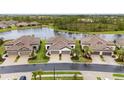 Expansive aerial view showcasing modern homes with tile roofs, well-manicured lawns, and a peaceful lake setting at 249 Tracino Ter, Nokomis, FL 34275