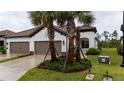 Charming single-story home featuring a tile roof, landscaped front yard with palm trees, and a two-car garage at 249 Tracino Ter, Nokomis, FL 34275