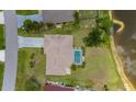 An aerial view of a home with a screened-in pool, landscaping, and close proximity to a lake at 25509 Arequipa Dr, Punta Gorda, FL 33983