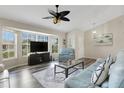 Bright living room with large windows, vaulted ceilings, ceiling fan, and hardwood floors at 25509 Arequipa Dr, Punta Gorda, FL 33983