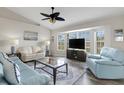 Bright living room with large windows, vaulted ceilings, ceiling fan, and hardwood floors at 25509 Arequipa Dr, Punta Gorda, FL 33983