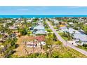 Breathtaking aerial view of a coastal community with houses, lush trees, and the ocean in the background at 301 Gulf Dr, Venice, FL 34285