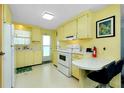 Cozy kitchen that includes appliances, cabinetry and a table with breakfast bar at 304 Roma Rd, Venice, FL 34285
