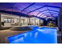 Screened-in pool with spa, rock waterfall feature, and ample seating area overlooking a manicured yard at 329 Myrtle Ave, Nokomis, FL 34275