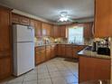 Bright kitchen featuring well-lit tile floors, wood cabinets, granite counters and stainless steel appliances at 3311 Papaya Rd, Venice, FL 34293
