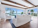 Bright living room with wooden beam ceiling, hardwood floors, and waterfront views at 3516 Casey Key Rd, Nokomis, FL 34275