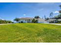 Charming single-story home featuring a manicured lawn and a pristine driveway leading to an attached two-car garage at 381 La Playa Ln, Port Charlotte, FL 33953