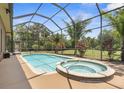 Inviting screened-in pool and spa area, perfect for relaxation and enjoying the beautiful surroundings at 3950 Pepper Ln, North Port, FL 34287