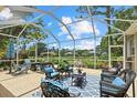Enclosed patio with a variety of seating options and an expansive view of the landscaped backyard at 427 Autumn Chase Dr, Venice, FL 34292