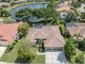 Stunning aerial view of a home with pool, screened lanai and lake frontage in a beautiful community at 463 Park Trace Blvd, Osprey, FL 34229