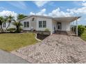 Charming home featuring a brick driveway, carport, and manicured lawn at 485 Schooner St, North Port, FL 34287