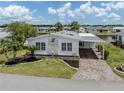 Charming home features a carport, landscaped yard, and canal view at 485 Schooner St, North Port, FL 34287