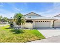 Charming single-story home with a well-manicured lawn, palm tree, and a two-car garage at 57 Sandstone Cir, Venice, FL 34293